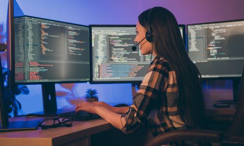 Photo of hard-working programmer consulting her colleagues at late night waiting, shift to end sitting before screens