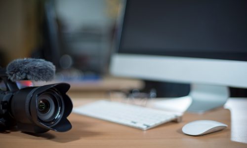 Video editing workstation with video camera beside monitor