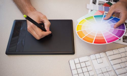 Designer using graphics tablet and colour wheel in the office